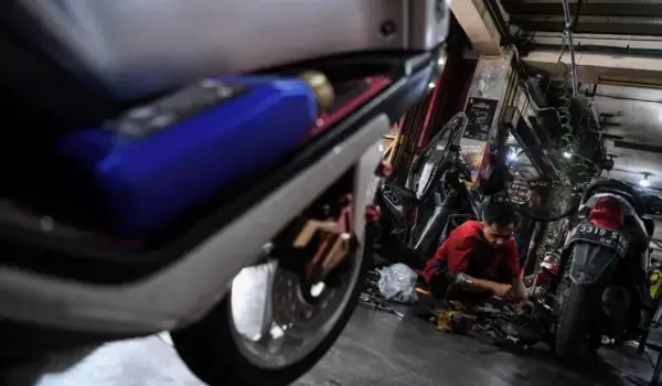 Mekanik memperbaiki motor di salah satu bengkel motor di Pasar Minggu, Jakarta Selatan, Minggu (16/4/2023). Foto: Sigid Kurniawan/ANTARA FOTO