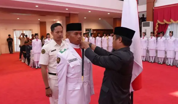Gubernur Sulawesi Selatan, Andi Sudirman Sulaiman (kanan), mengukuhkan 73 anggota Paskibraka Tingkat Provinsi Tahun 2025 di Aula Asta Cita, Rumah Jabatan Gubernur Sulsel, Jumat (15/8/2025).