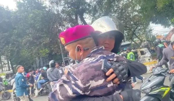 Seorang ojek online memeluk petugas TNI usai melakukan aksi di kawasan Mako Brimob Kwitang, Jakarta, Jumat (29/8/2025).